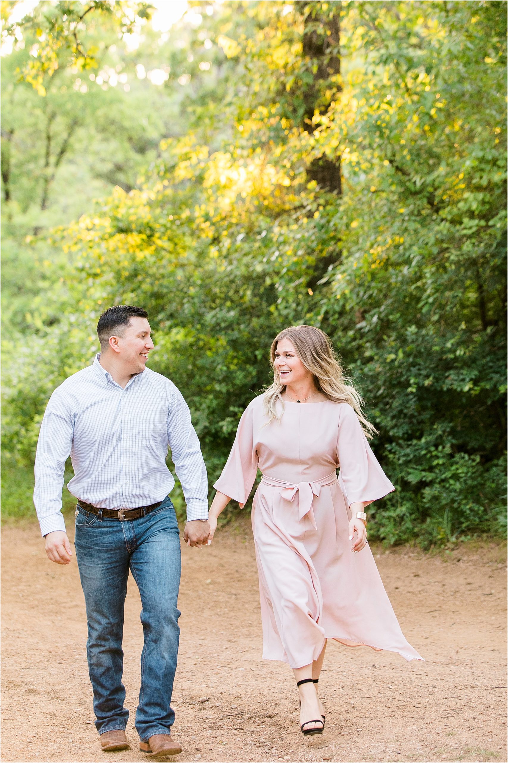 A young happy couple walking in the woods at Elmer Oliver State Park during their Engagement Session