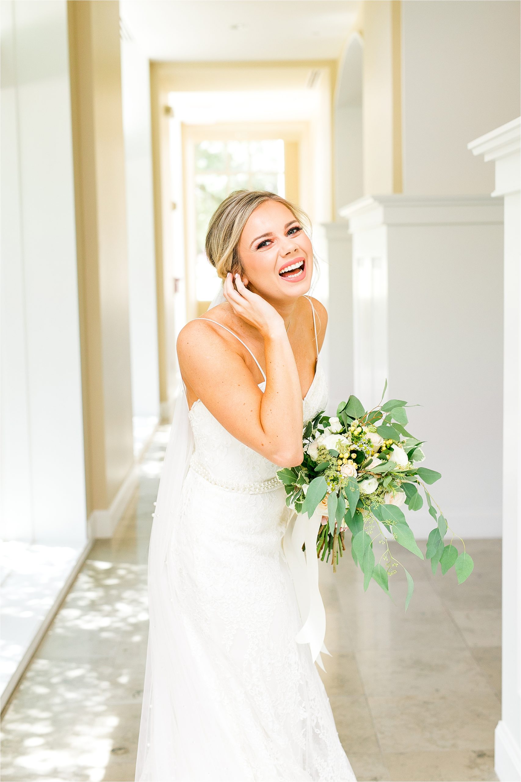 A bride laughs into the camera during bridal portraits before her Dallas, Texas Wedding Ceremony at Prestonwood Chapel 