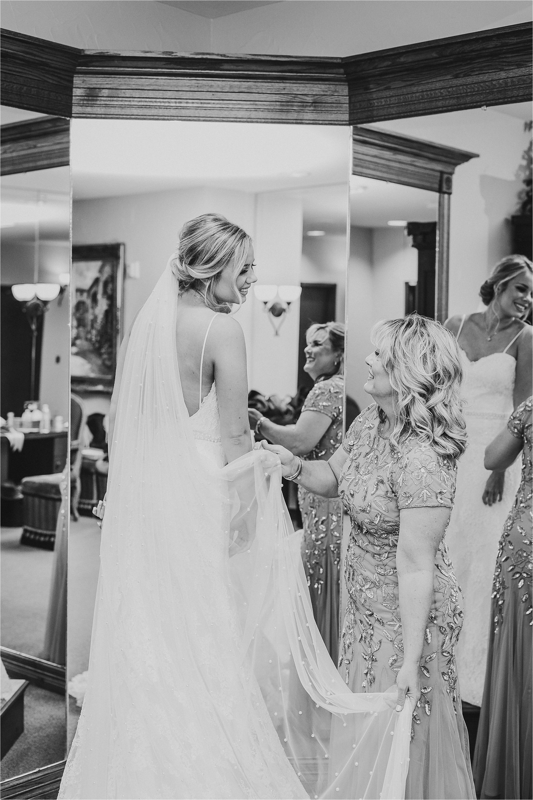 A bride and her mother share a moment as the mom adjusts her wedding veil before her Prestonwood Chapel Wedding in Plano, Texas 