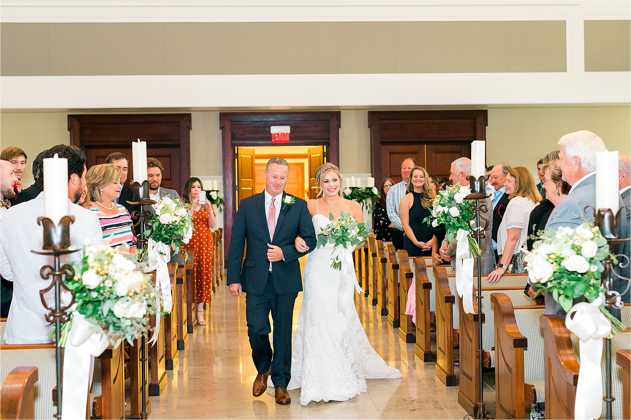 A bride and her dad happily walk down the aisle for her wedding ceremony at Prestonwood Chapel in Plano, Texas 