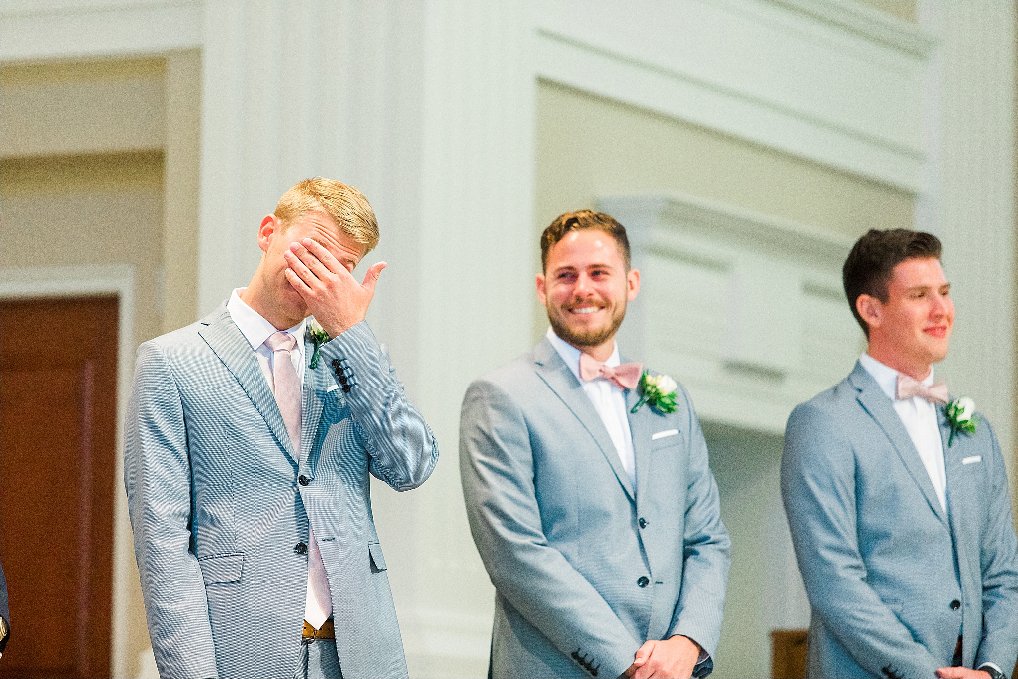 A groom hides his tears as his bride walks down the aisle for their DFW Wedding at Prestonwood Chapel in Plano, Texas 
