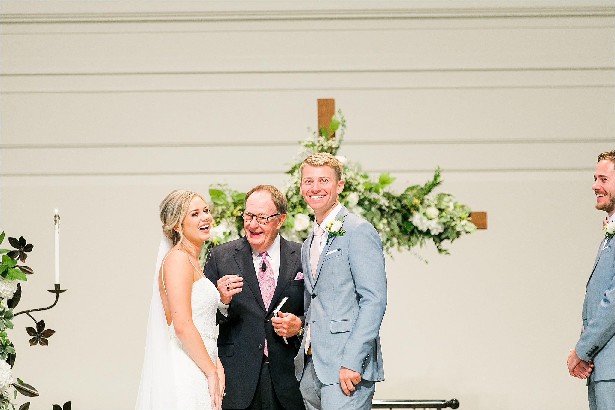 A couple laughs looking out toward their guests during their wedding ceremony at Prestonwood Baptist Church in Plano, Texas 