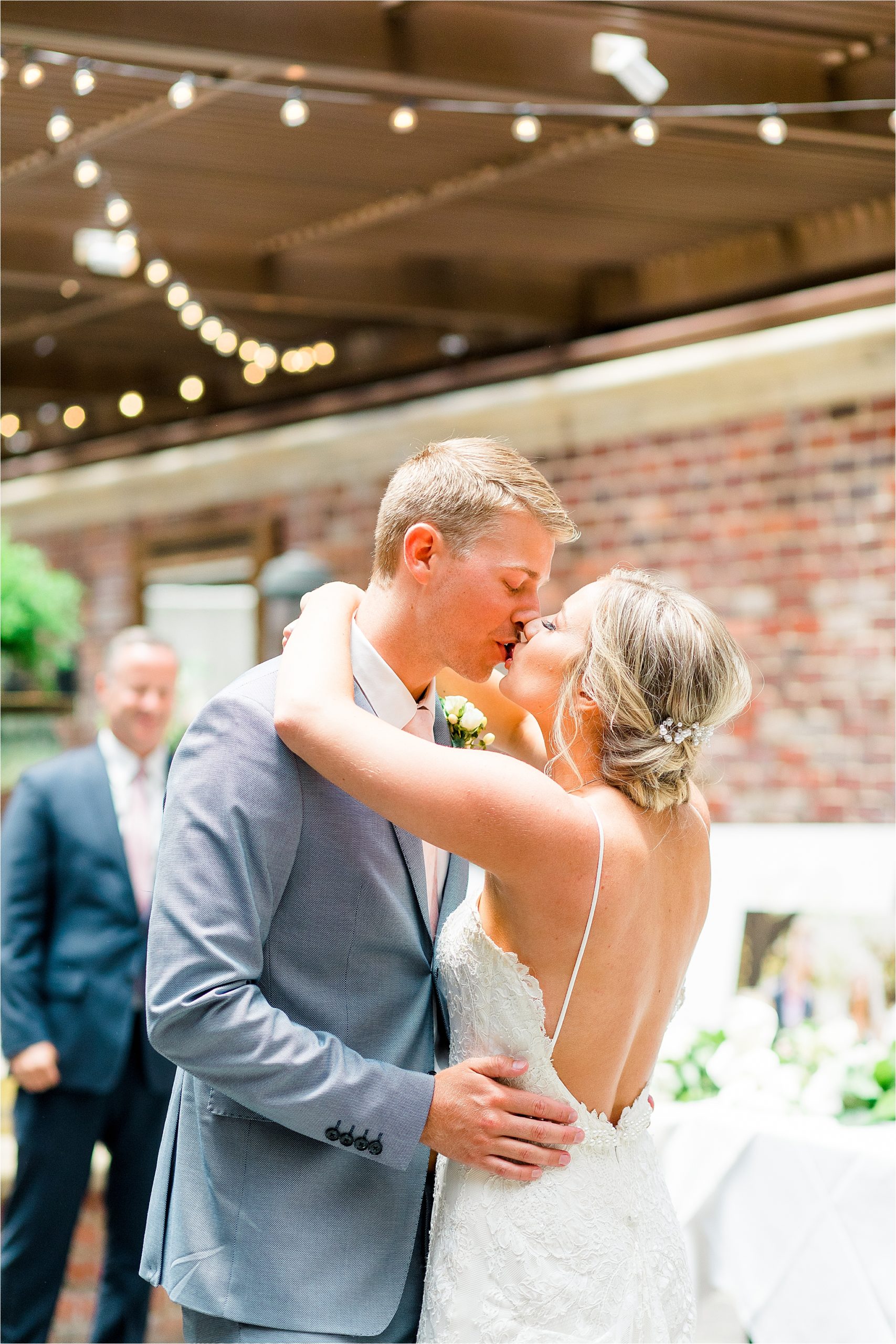 A happy newlywed couple share a kiss at their garden reception at III Forks Dallas 