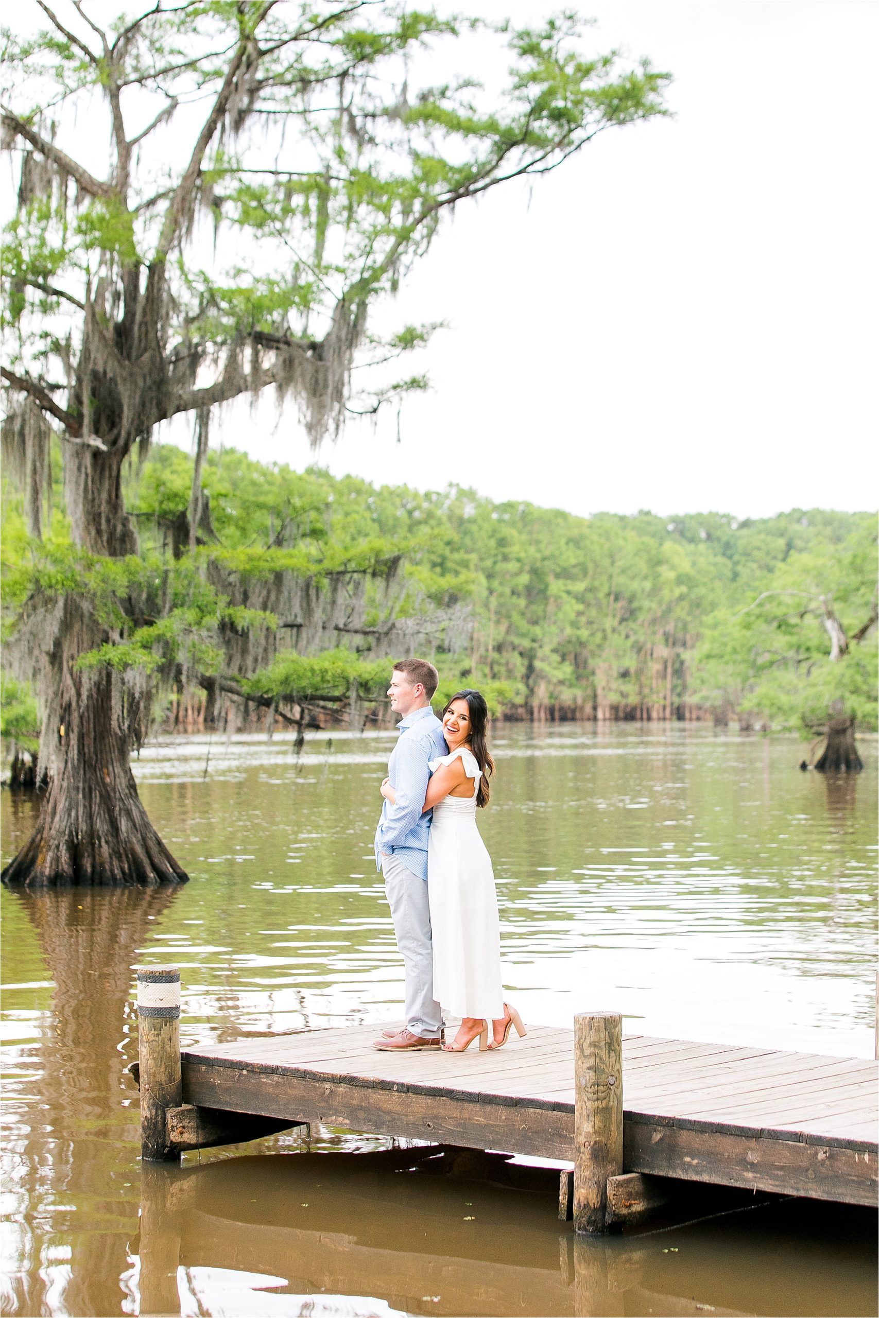 A bride to be embraces her fiance on a dock at Caddo Lake in East Texas by DFW Engagement Photographer 