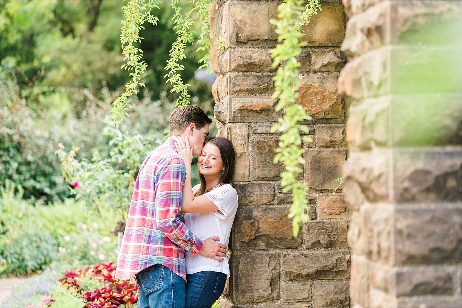 A copule giving Forehead kisses during their dfw engagement session at The Fort worth Botanic Gardens