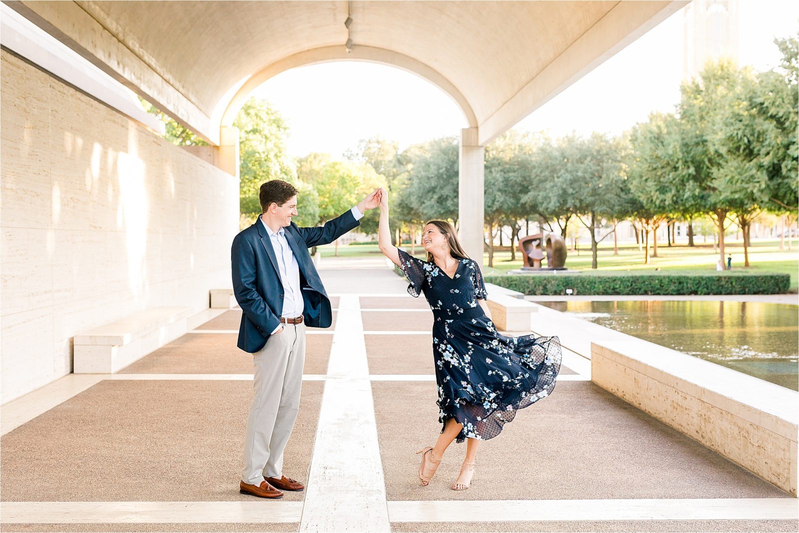 A couple dancing under the arches during their engagement session at The Kimball Art Museum in Fort Worth, Texas
