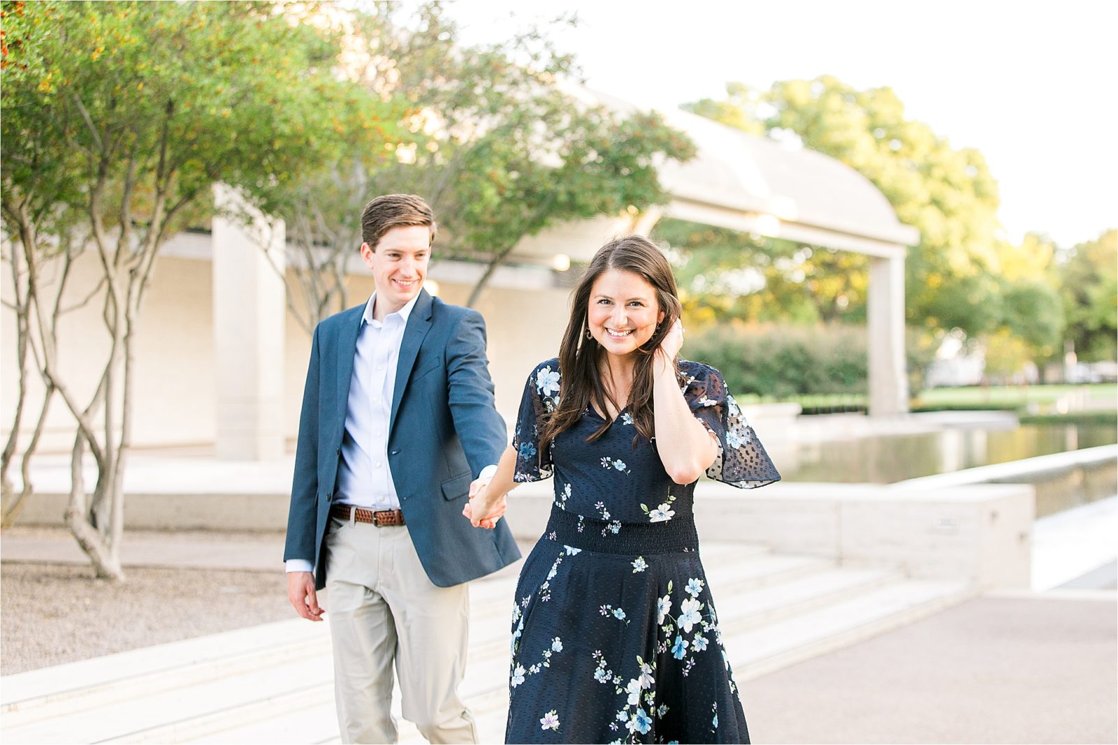 A bride to be playfully pulls her fiance toward the camera during their engagement session at Kimball Art Museum in Fort Worth, Texas 