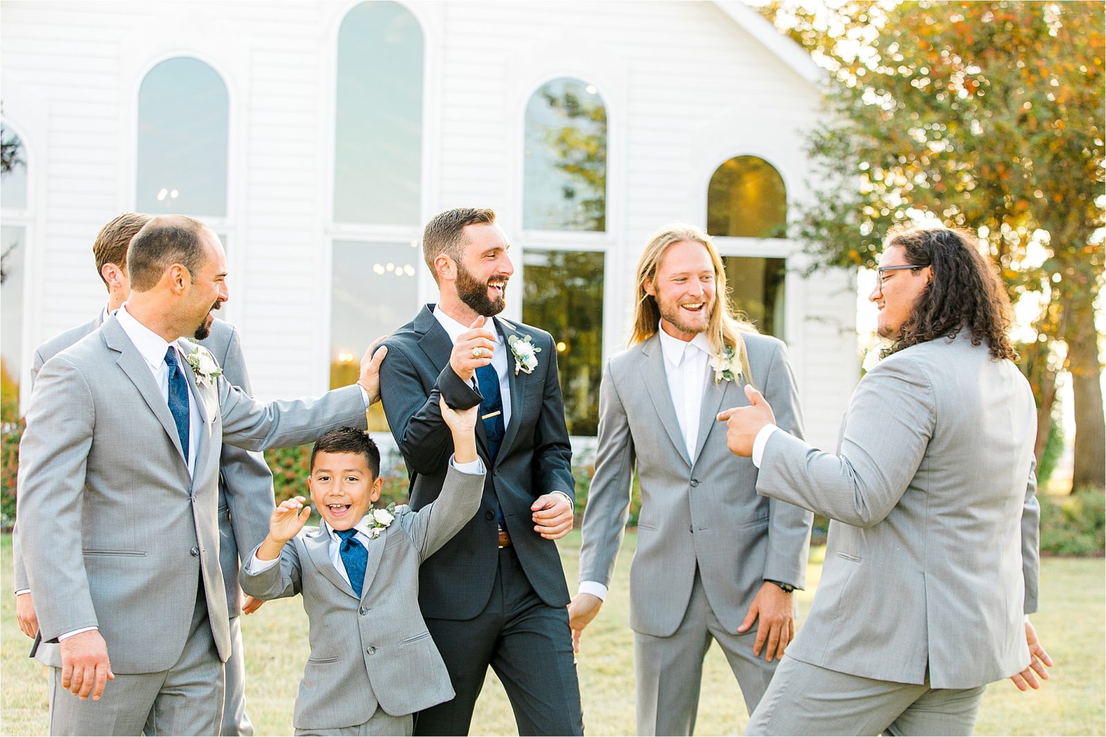 A groom and his groomsmen joke around with each other before the groom walks down the aisle at a White Wedding Chapel in DFW
