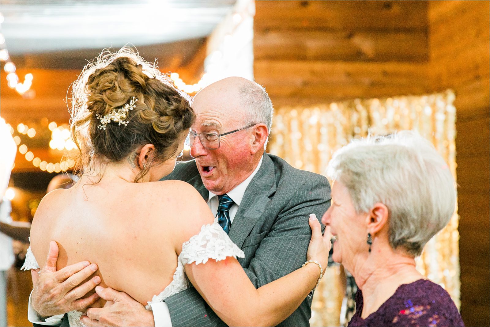 A bride receives a hug by her grandfather and share a very happy moment during her DFW Wedding Reception at Rustic Grace Estate by Jillian Hogan Photography 