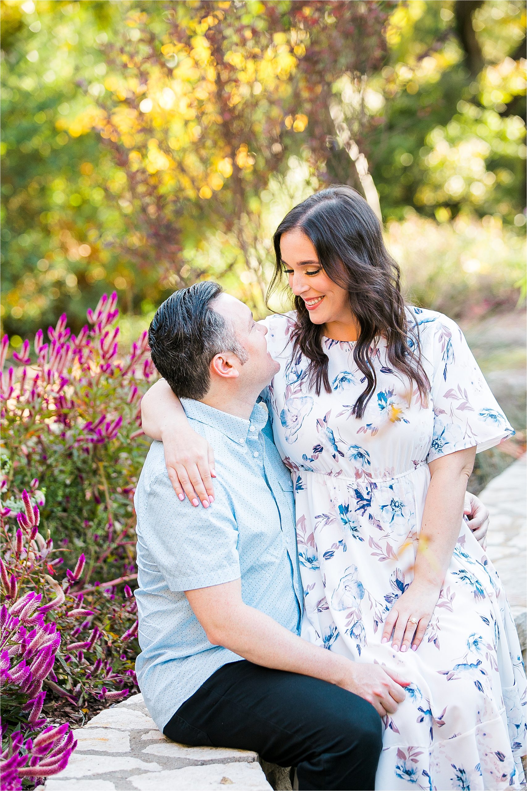 A couple shares a hug and smiles at each other during their DFW Engagement Session at The Fort Worth Botanic Garden 