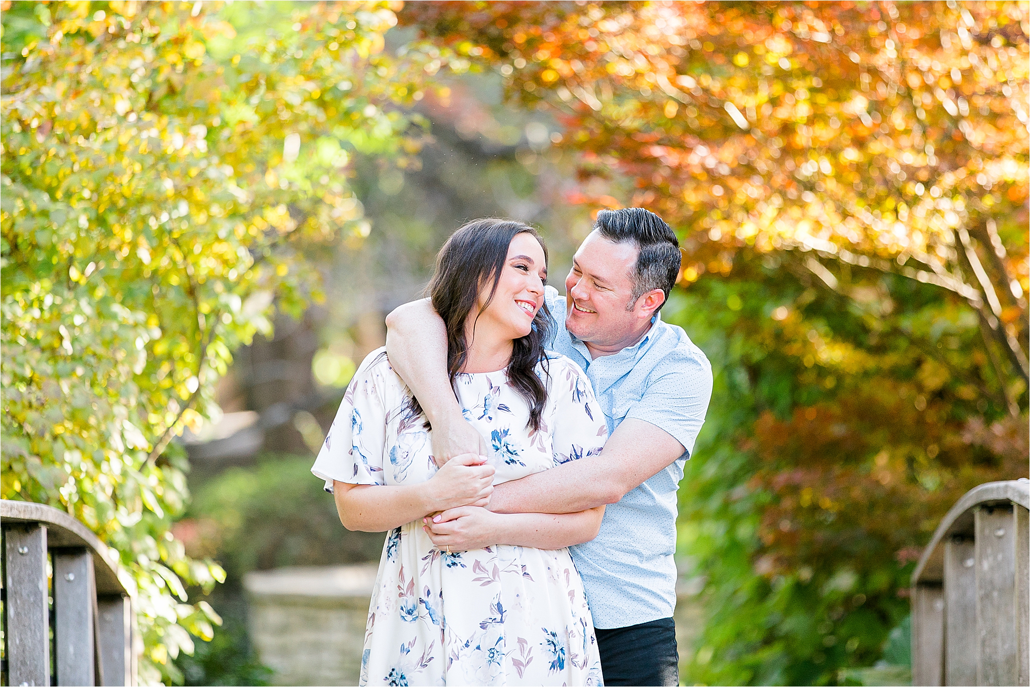 A bride to be being bear-hugged by her fiance on a sunny, fall day at The Fort Worth Botanic Garden during their DFW Engagement Session with Jillian Hogan 