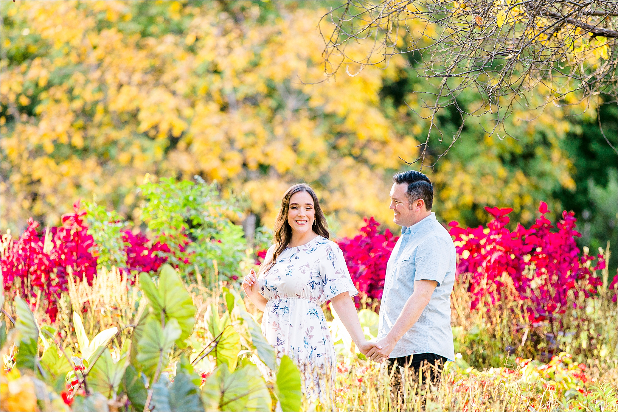 A bride to be pulls along her groom through a colorful field at The Fort Worth Botanic Garden during their DFW Engagement Session 