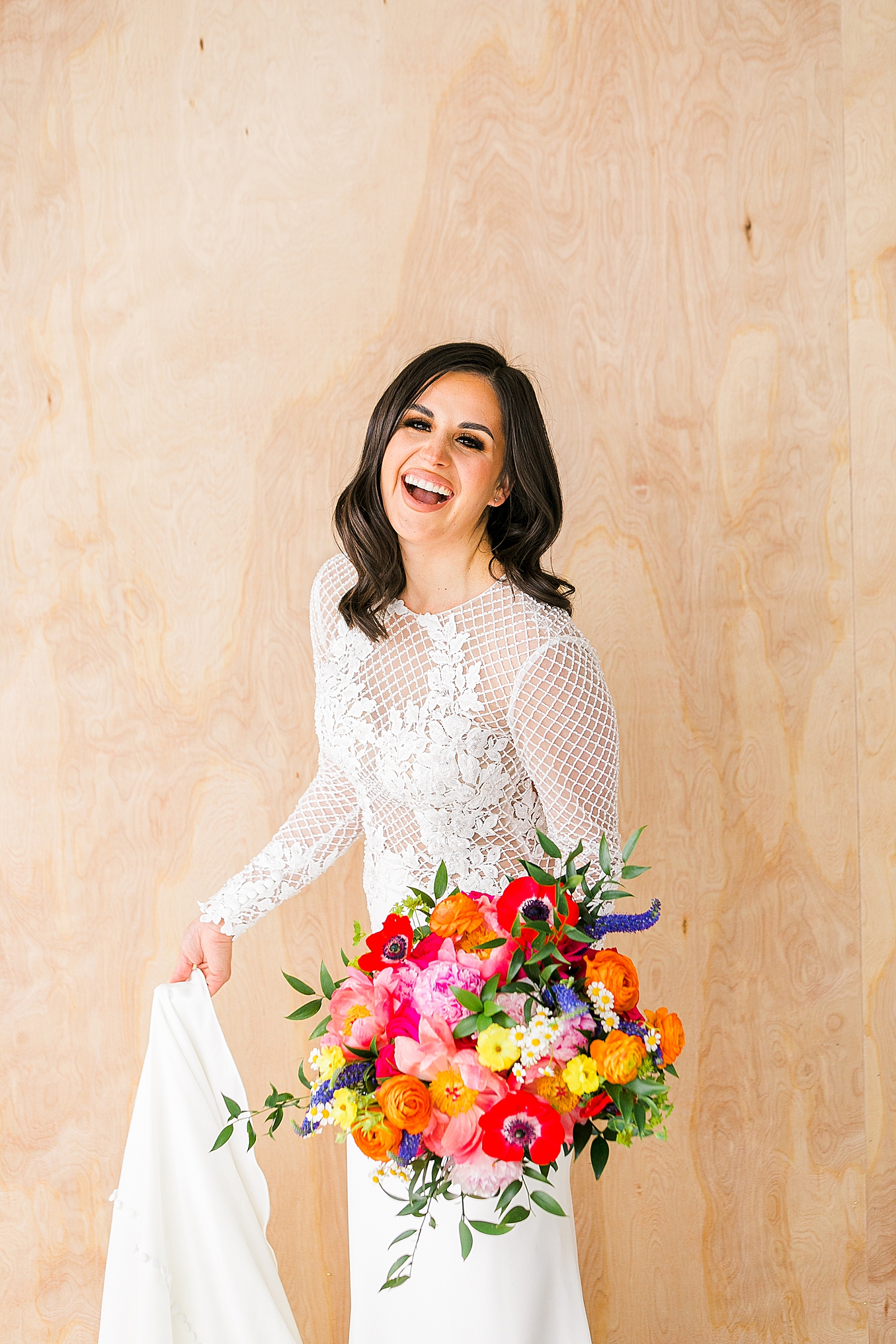 Smiling Bride holding her dress during her colorful studio bridal session in Dallas, TX 