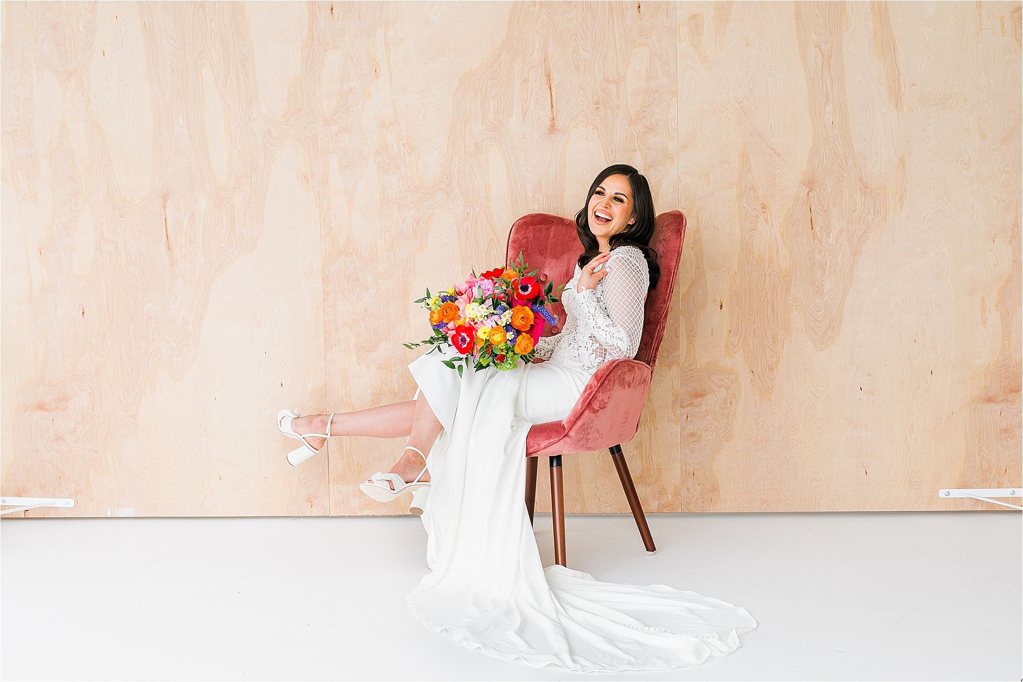 A smiling bride kicking her feet back in a chair during her bridal session at Black and Light Studios with DFW Wedding Photographer Jillian Hogan 