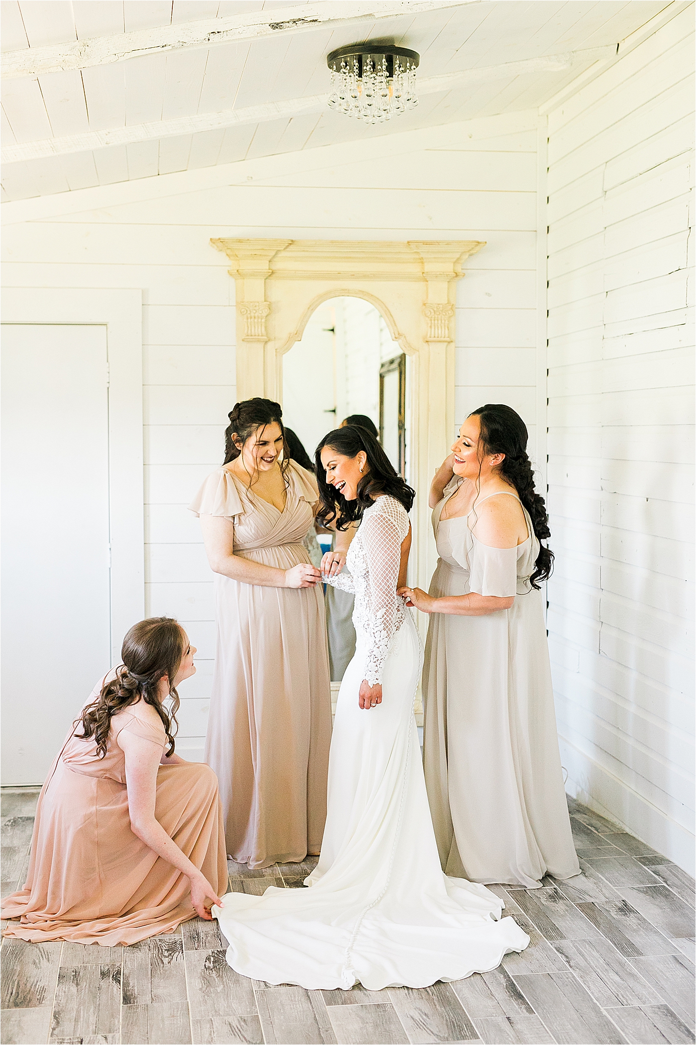 Joy and laughter as a bride puts on her wedding dress with her sisters at her Pineway Farms Wedding in East Texas with Jillian Hogan Photography 
