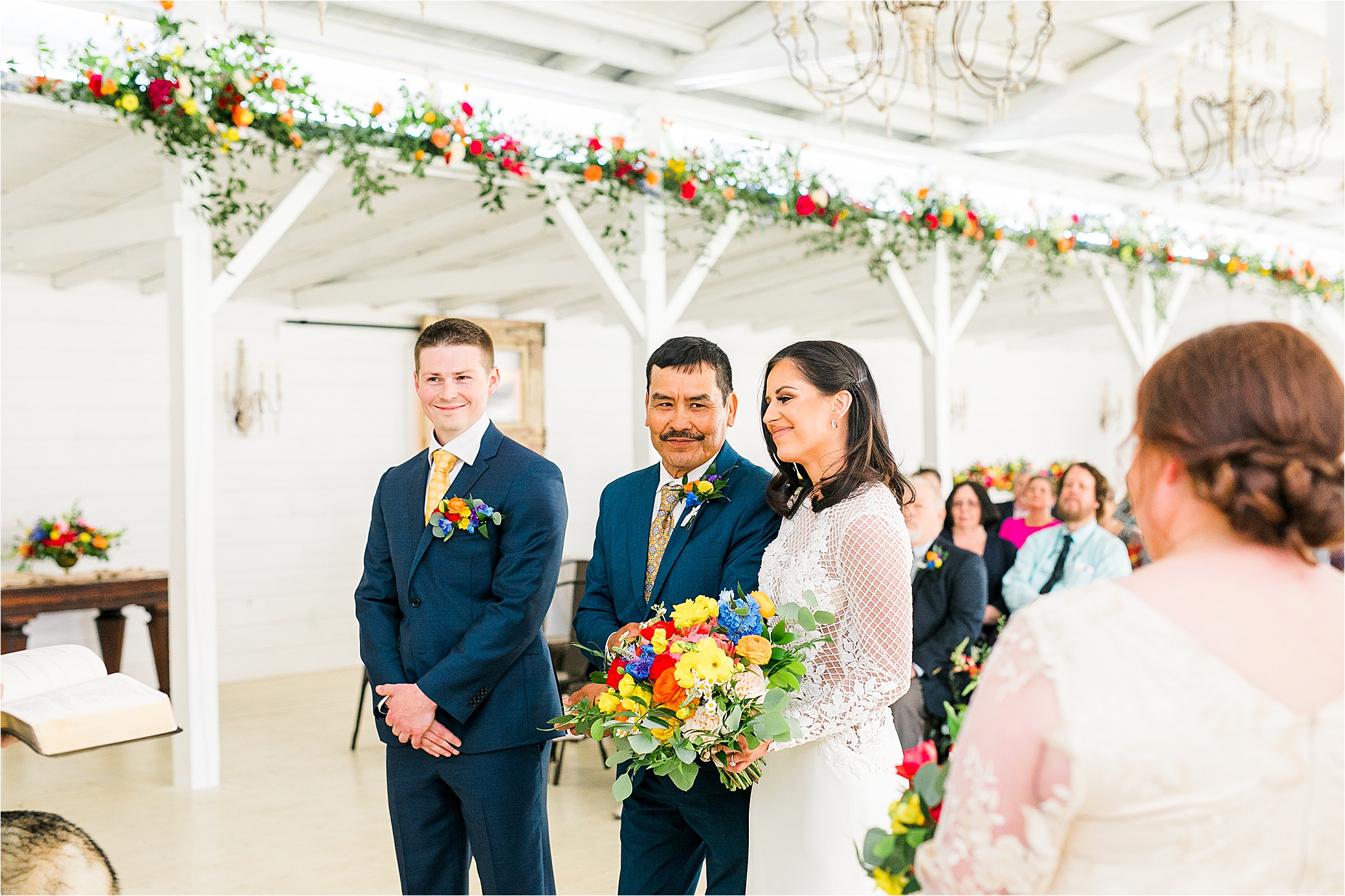 A groom smiles as his bride meets him down the aisle during their Pineway Farms Wedding Day with Hill Country Wedding Photographer, Jillian Hogan 