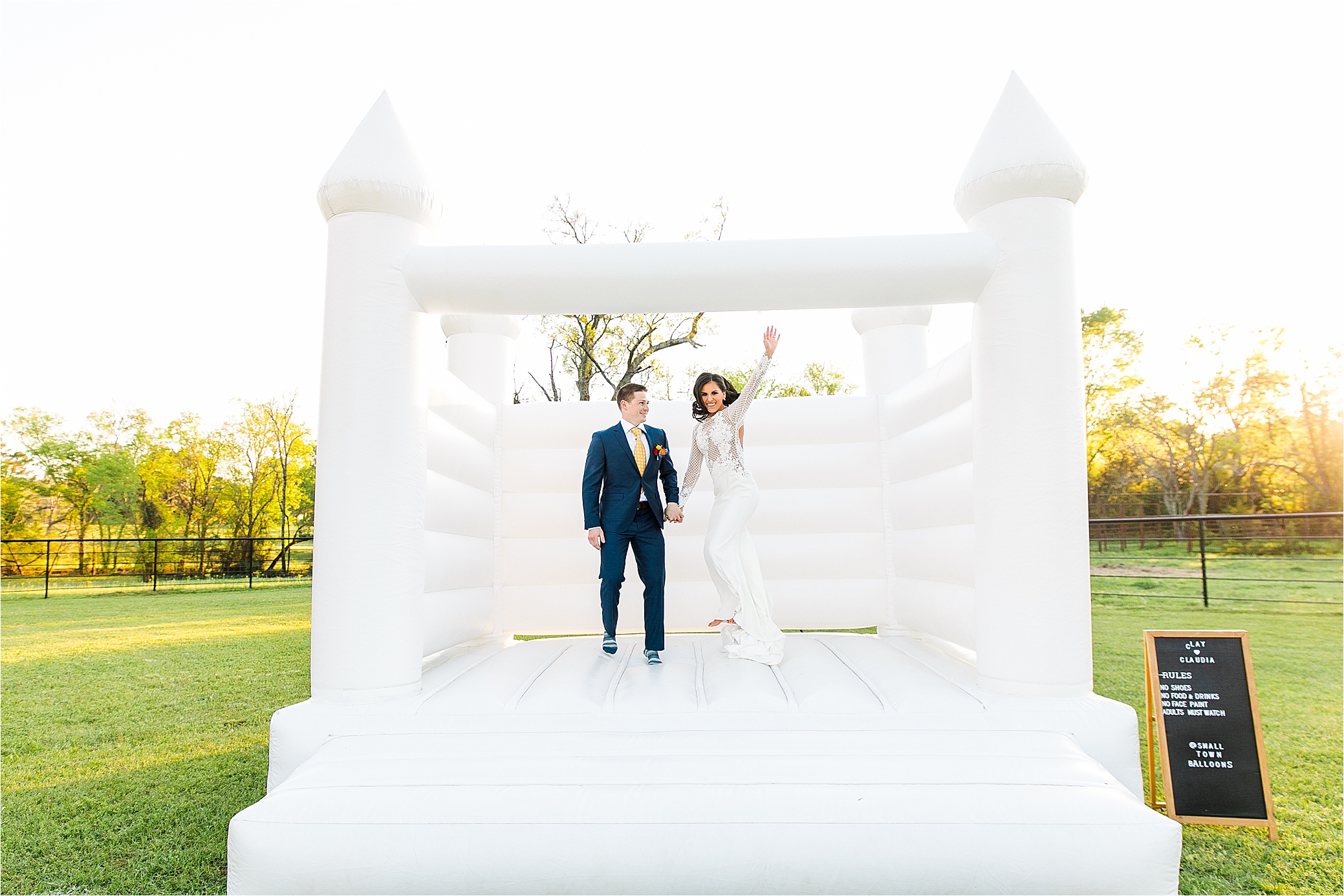 A newly married couple jumps in a bounce house during their portraits with Hill Country Wedding Photographer Jillian Hogan 