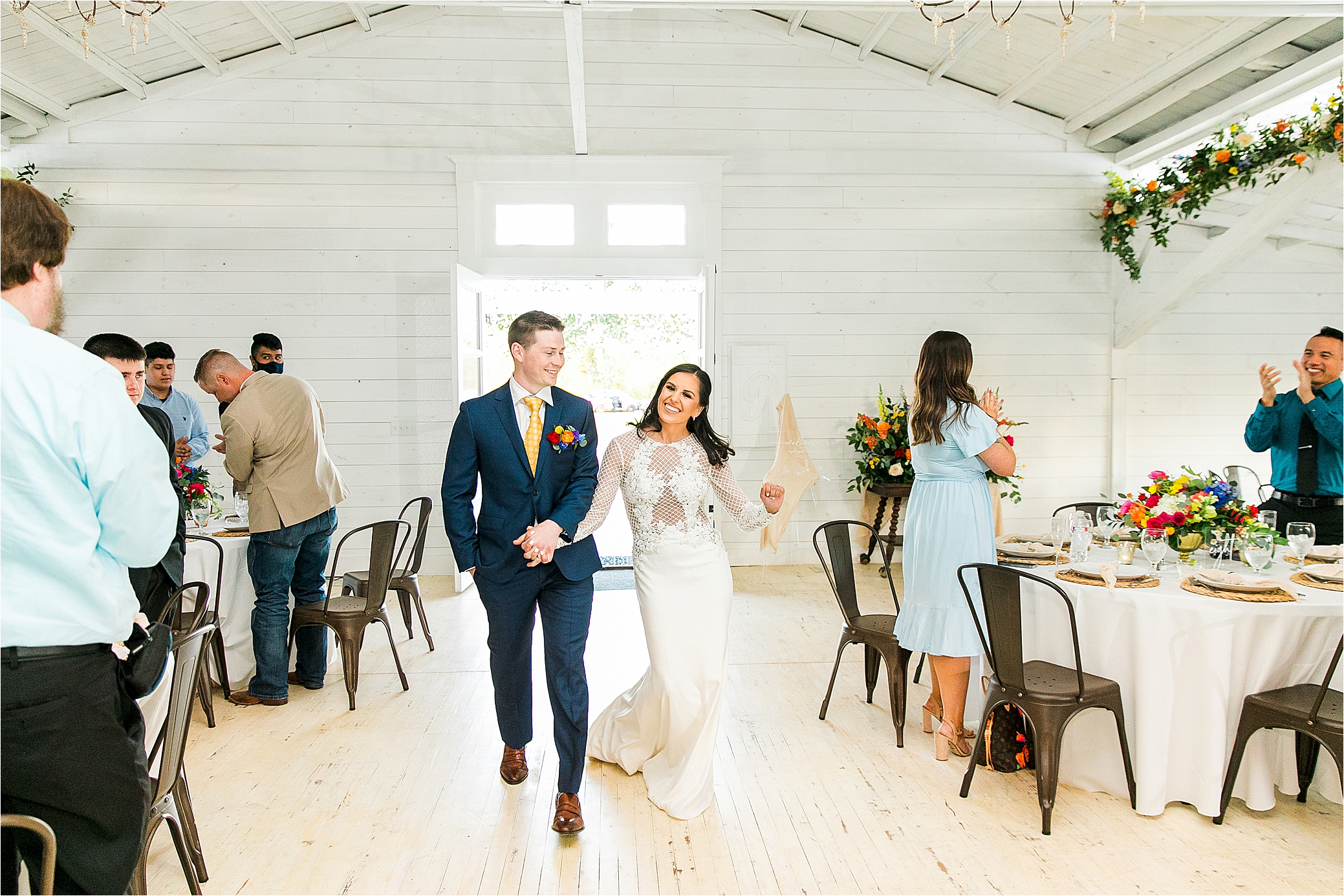 A newly married couple happily enters with Pineway Farms Wedding reception 