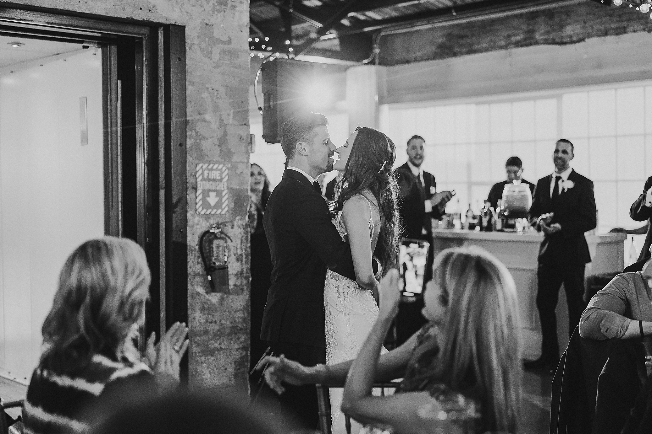 A couple enters and shares a kiss at their Hickory Street Annex Wedding Reception 