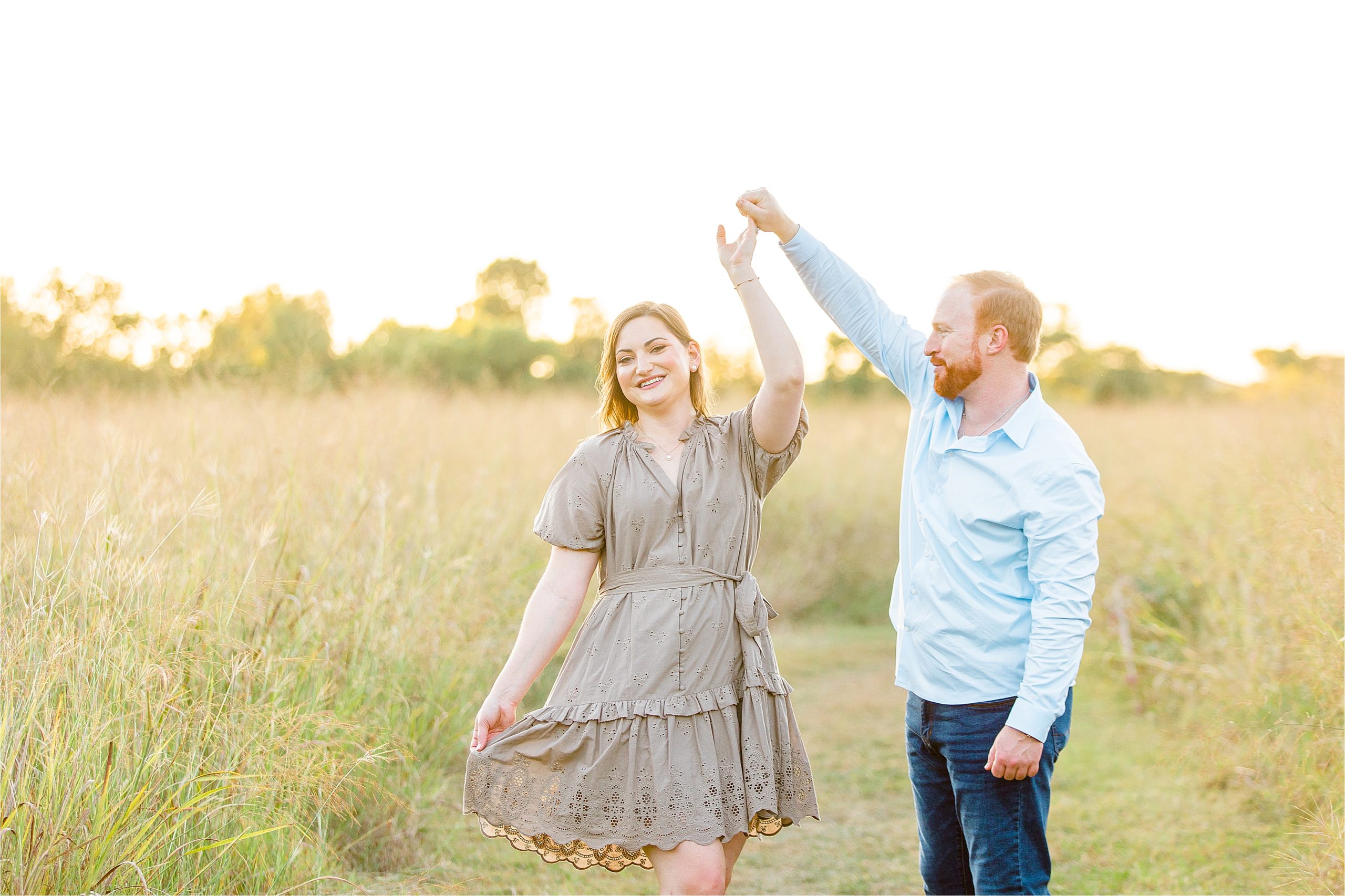 A couple dances in a field together as the sun sets behind them during their Texas Hill Country Engagement Session 