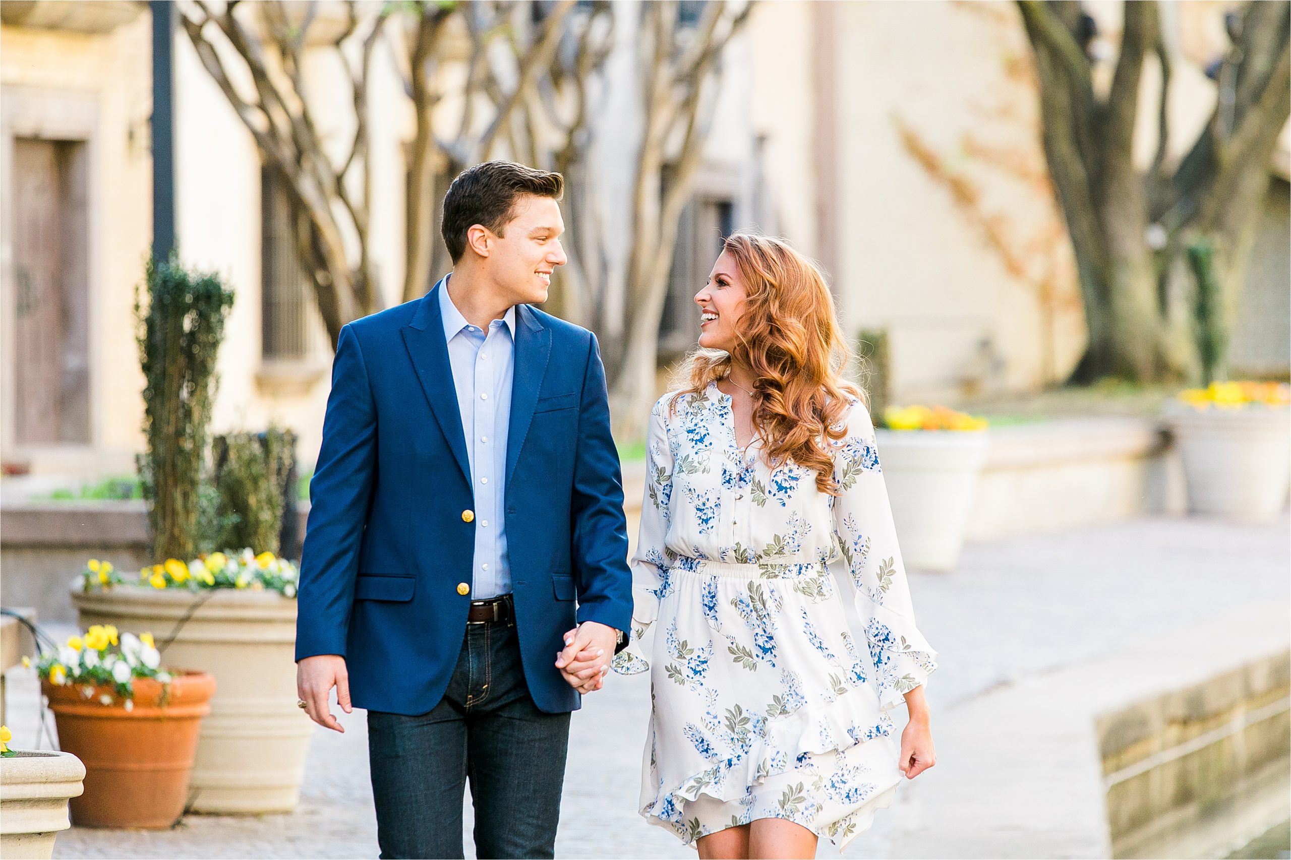 Miss Texas 2016 and her fiance stroll hand in hand wearing navy and a white dress during their san antonio riverwalk inspired engagement session with Jillian Hogan Photography 