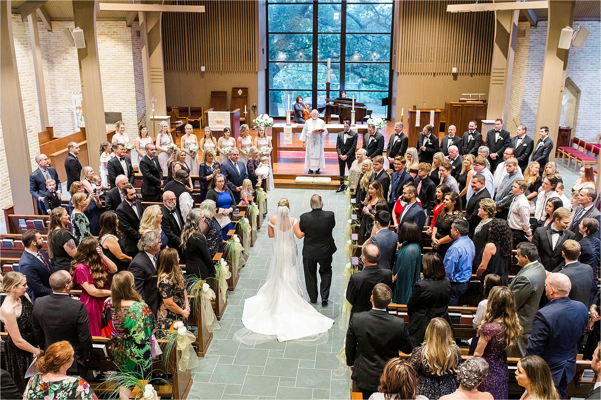 A full arial view from behind as the bride walks down the aisle to the groom in their San Antonio Church Ceremony 