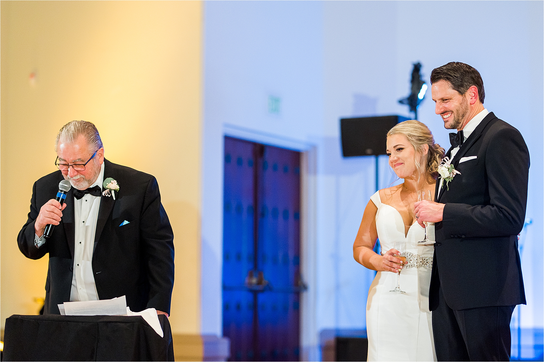 A bride emotionally smiles as her dad gives a speech during her McNay Art Museum Wedding