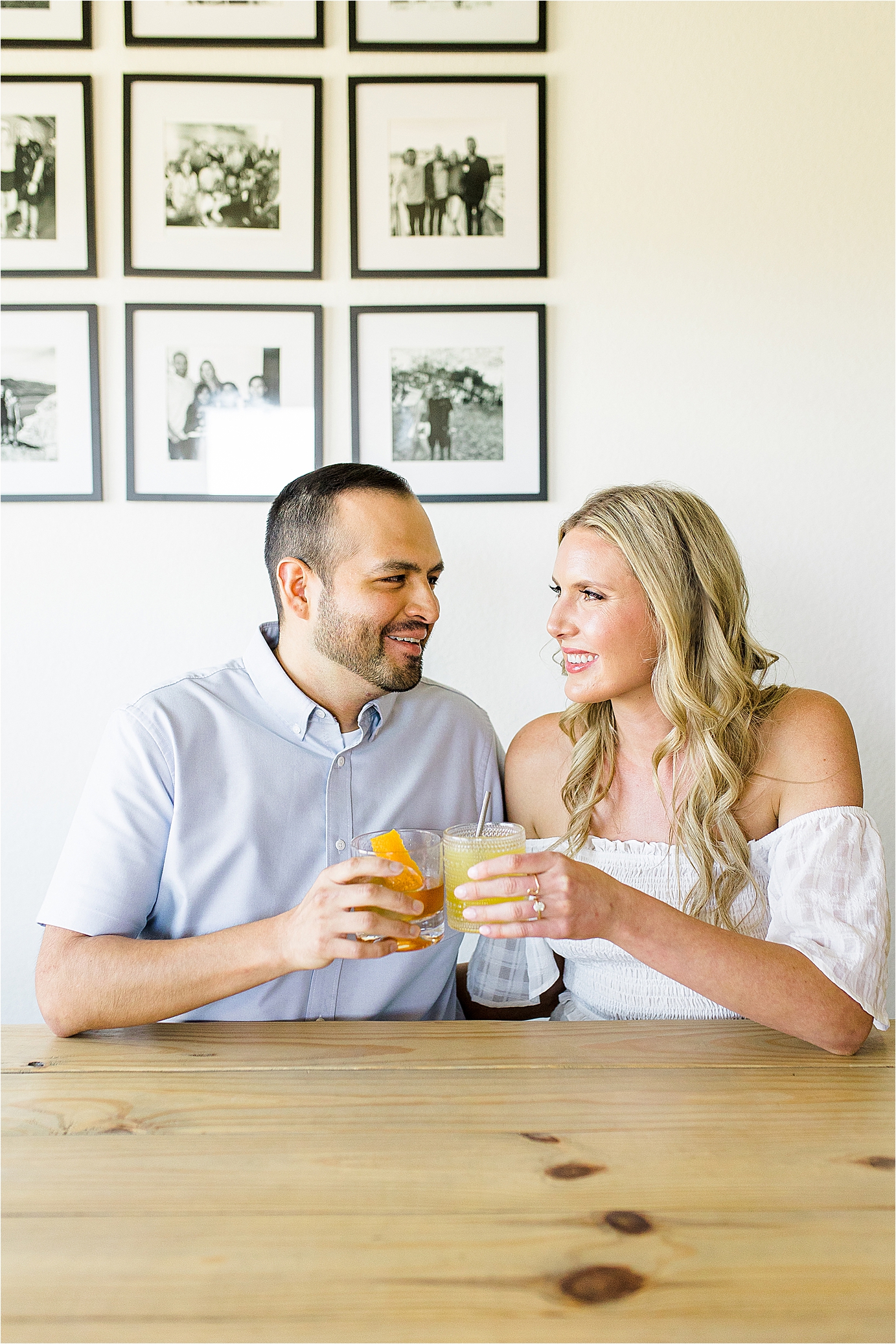 A couple cheers at their kitchen table during their in home engagement session in Austin, Texas