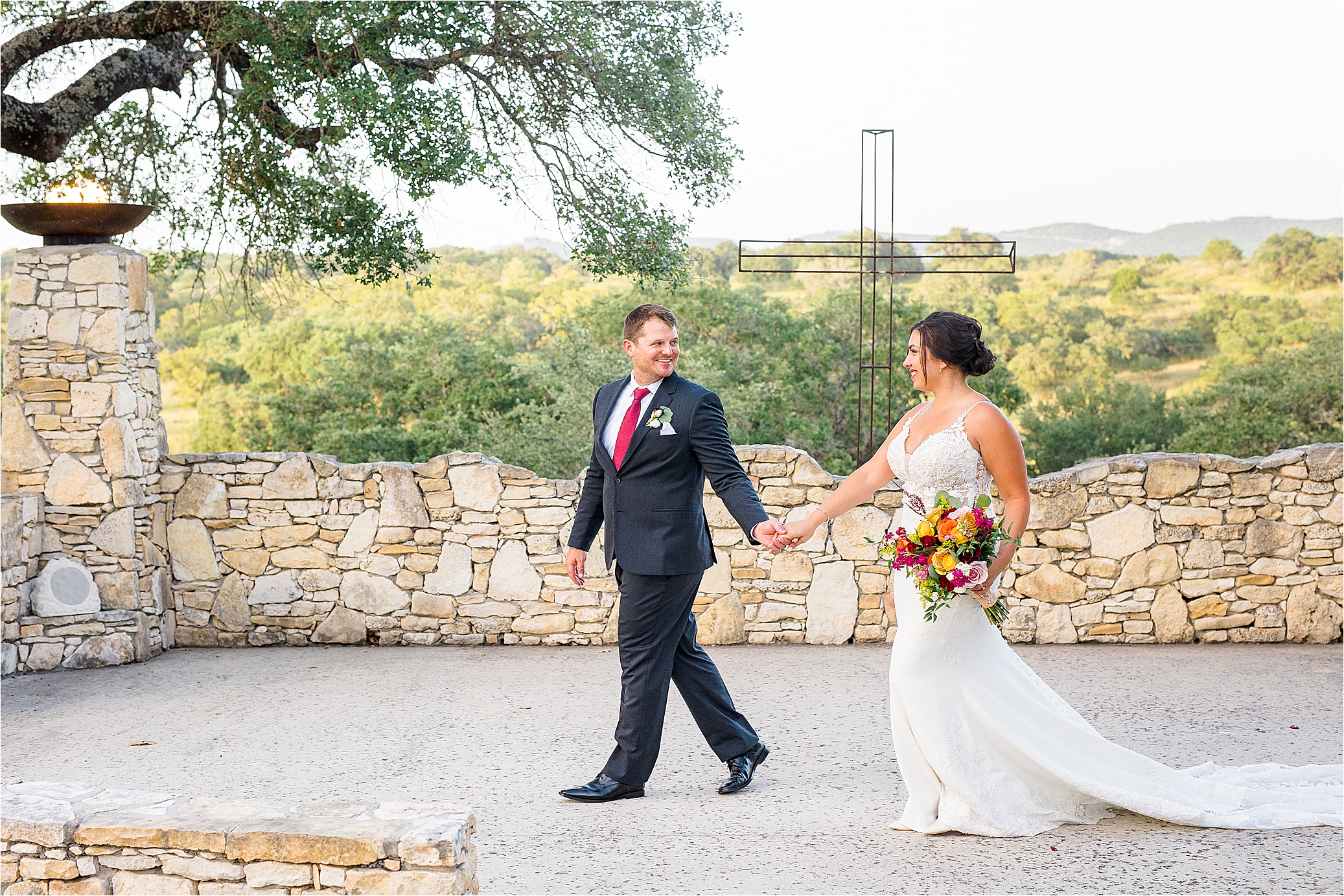 A groom leads his bride in front of sweeping hill country views at Paniolo Ranch in Boerne, Texas