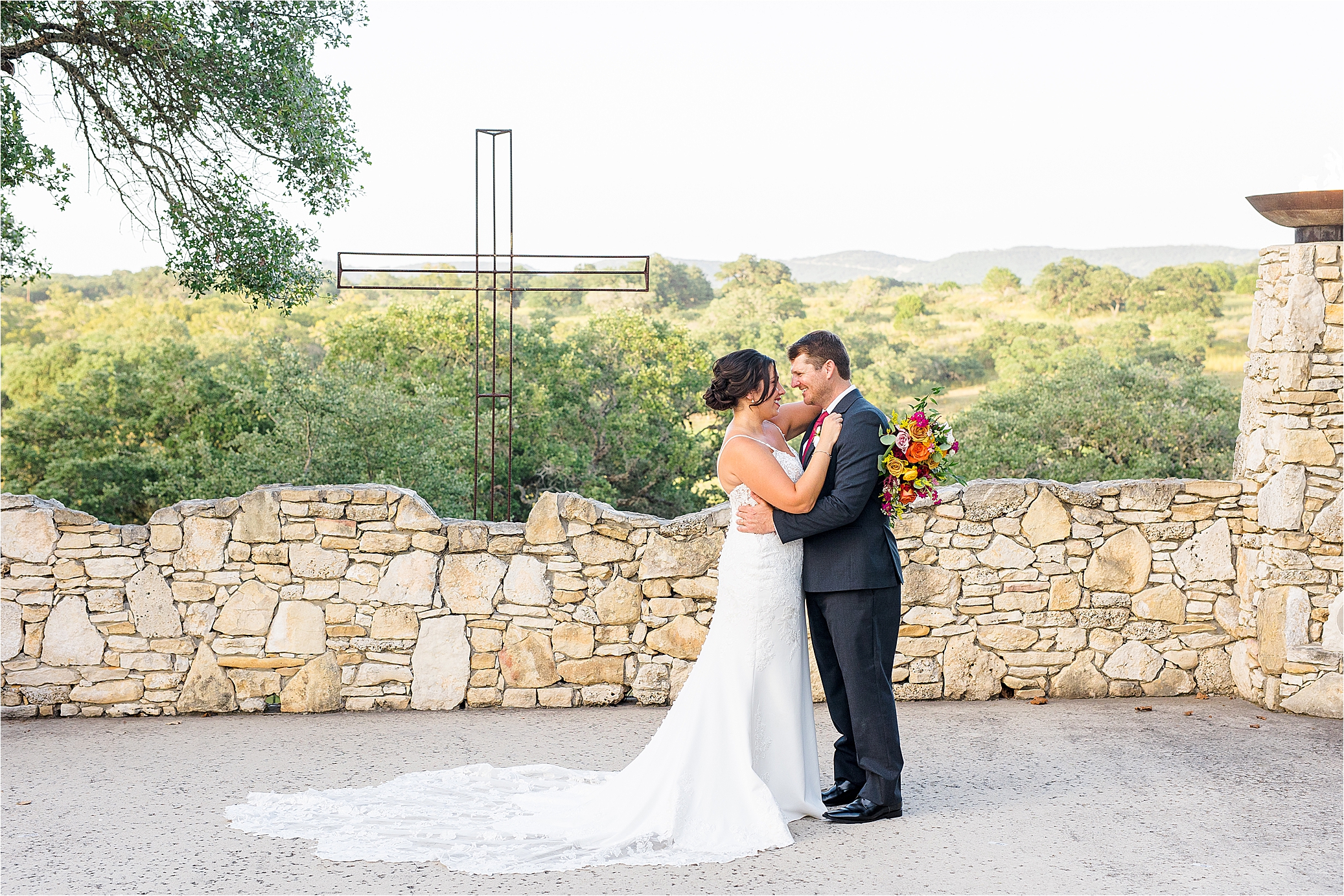 A bride and groom look at each other in front of beautiful hill country views at Paniolo Ranch in Boerne, Texas 