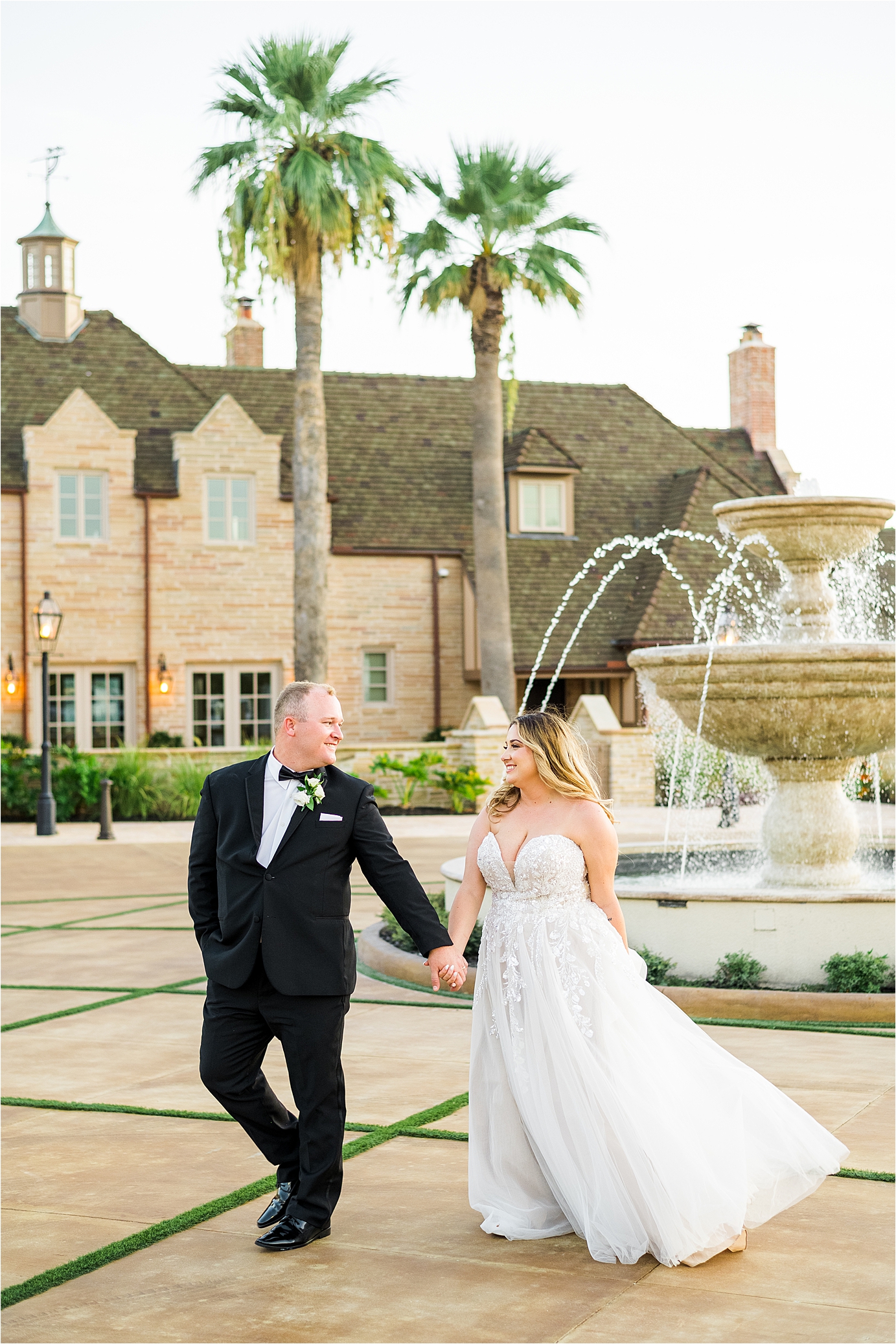 A bride and groom walk in front of Redberry Estate at Sunset on their wedding day 