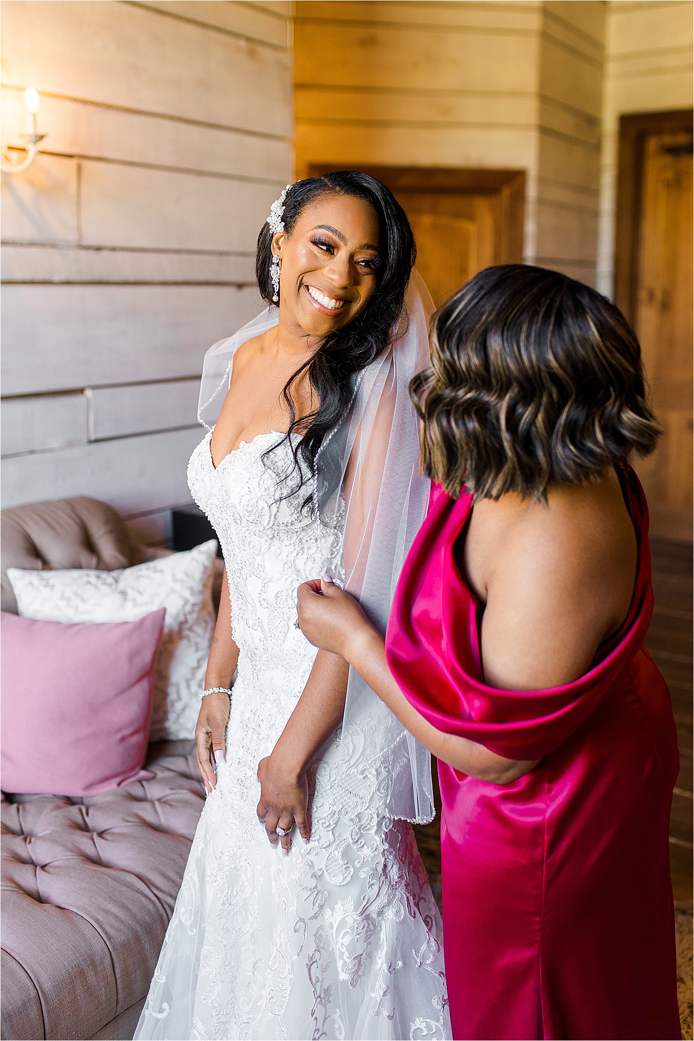 A bride smiles back at her mom as she puts on her veil in bridal suite at Morgan Creek in Aubrey, Texas 