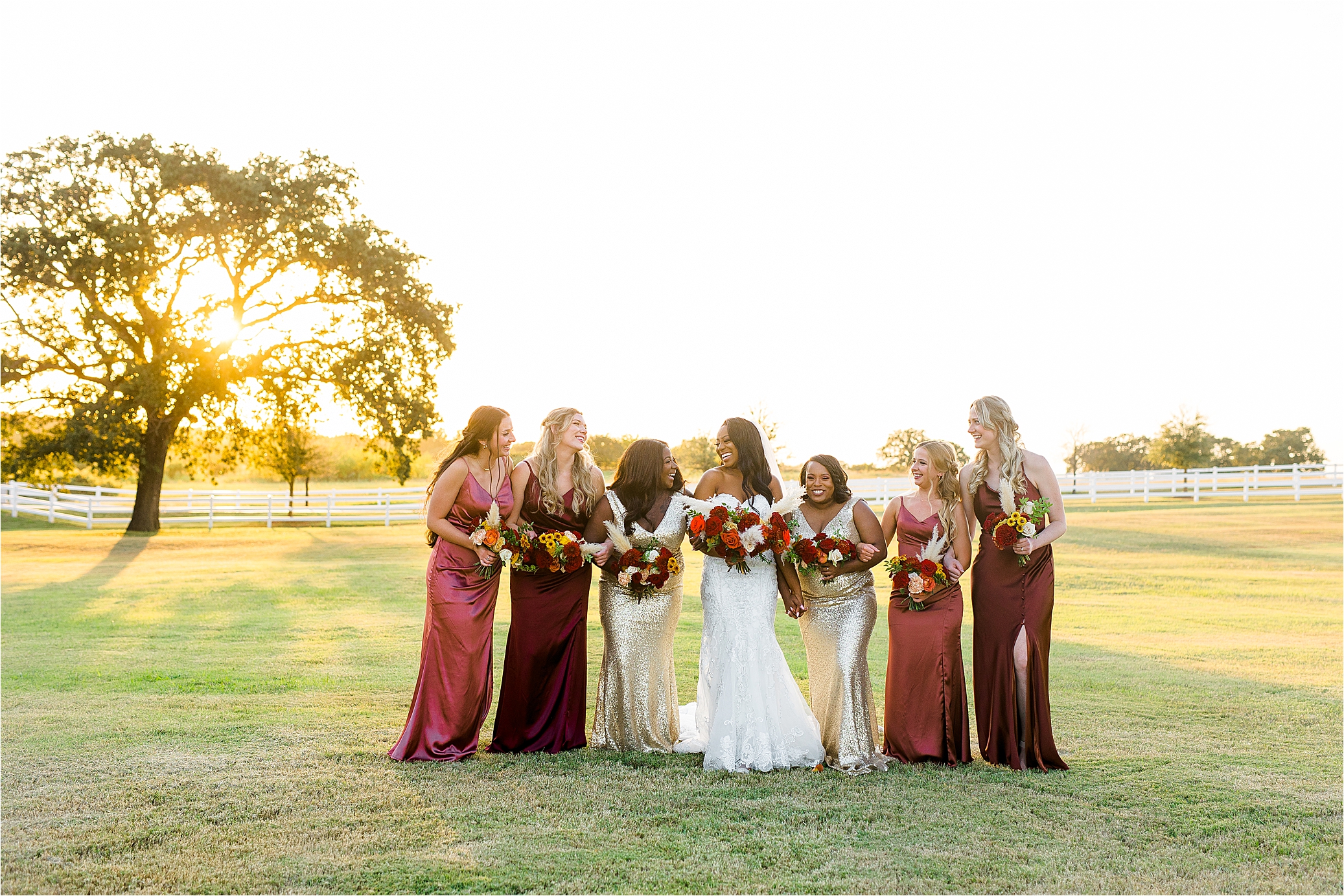 A bride and her bridesmaids walk with sunset behind them at The Milestone by Boerne Wedding Photographer Jillian Hogan 