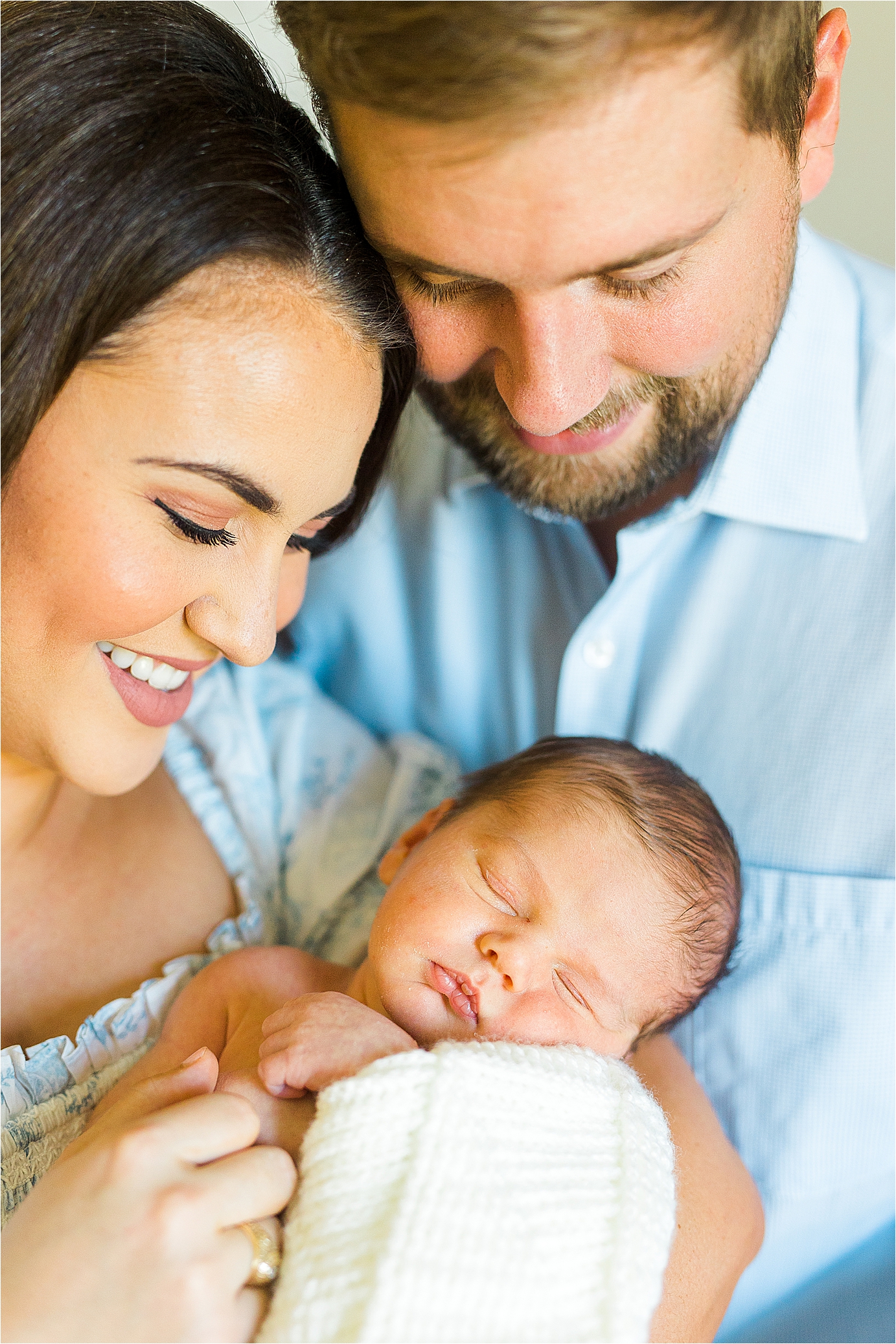 A close up of parents cuddling their newborn baby boy during family photos with lifestyle newborn photographer Jillian Hogan 