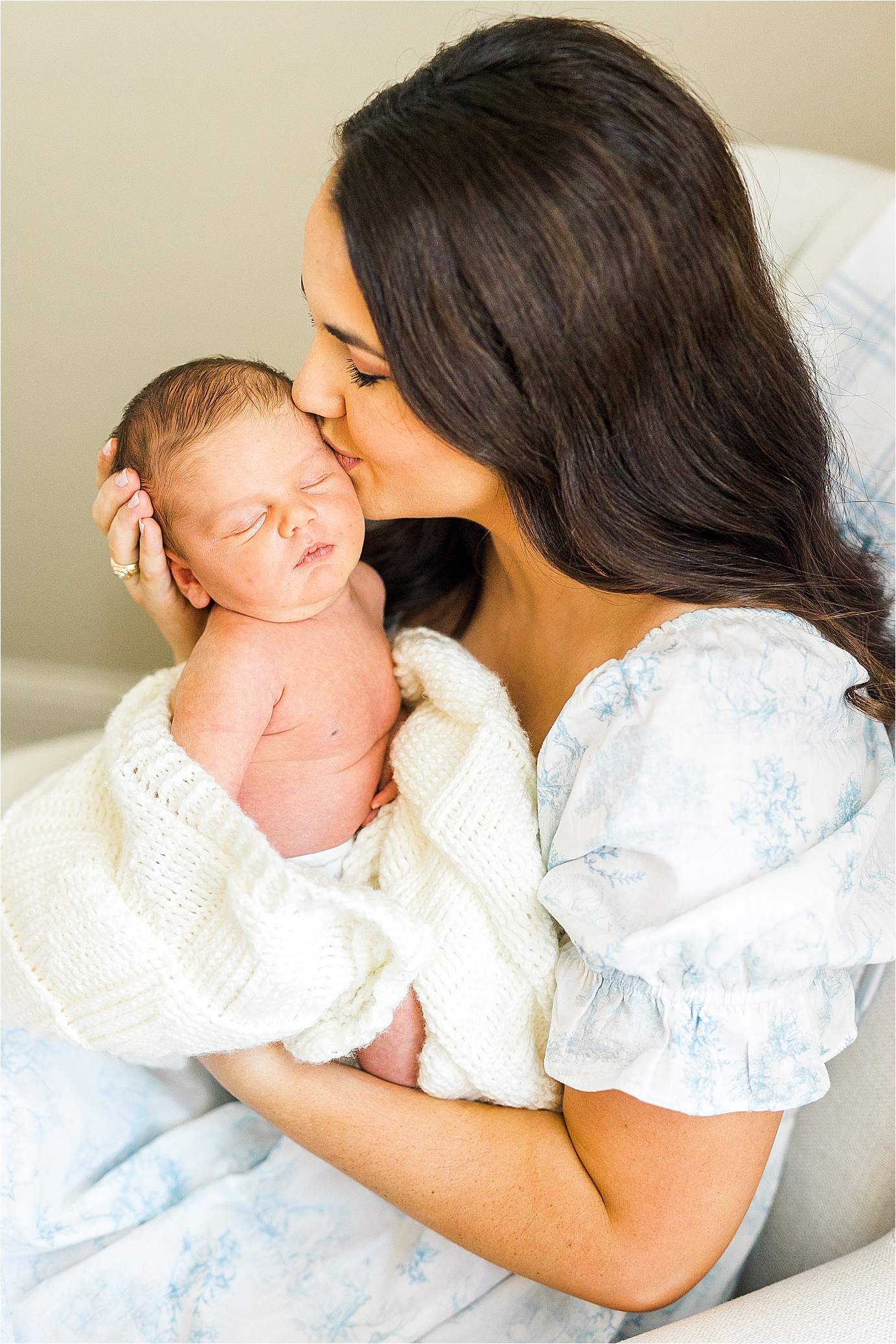 A mom kisses he newborn on the cheek during a lifestyle newborn session with San Antonio Photographer Jillian Hogan 
