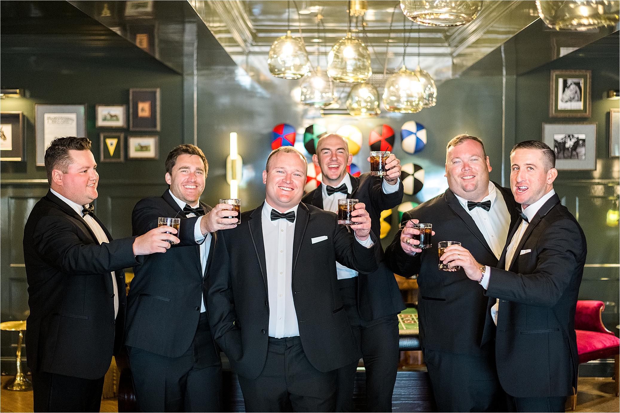 Groomsmen cheering in casino room on wedding day at The Redberry Estate