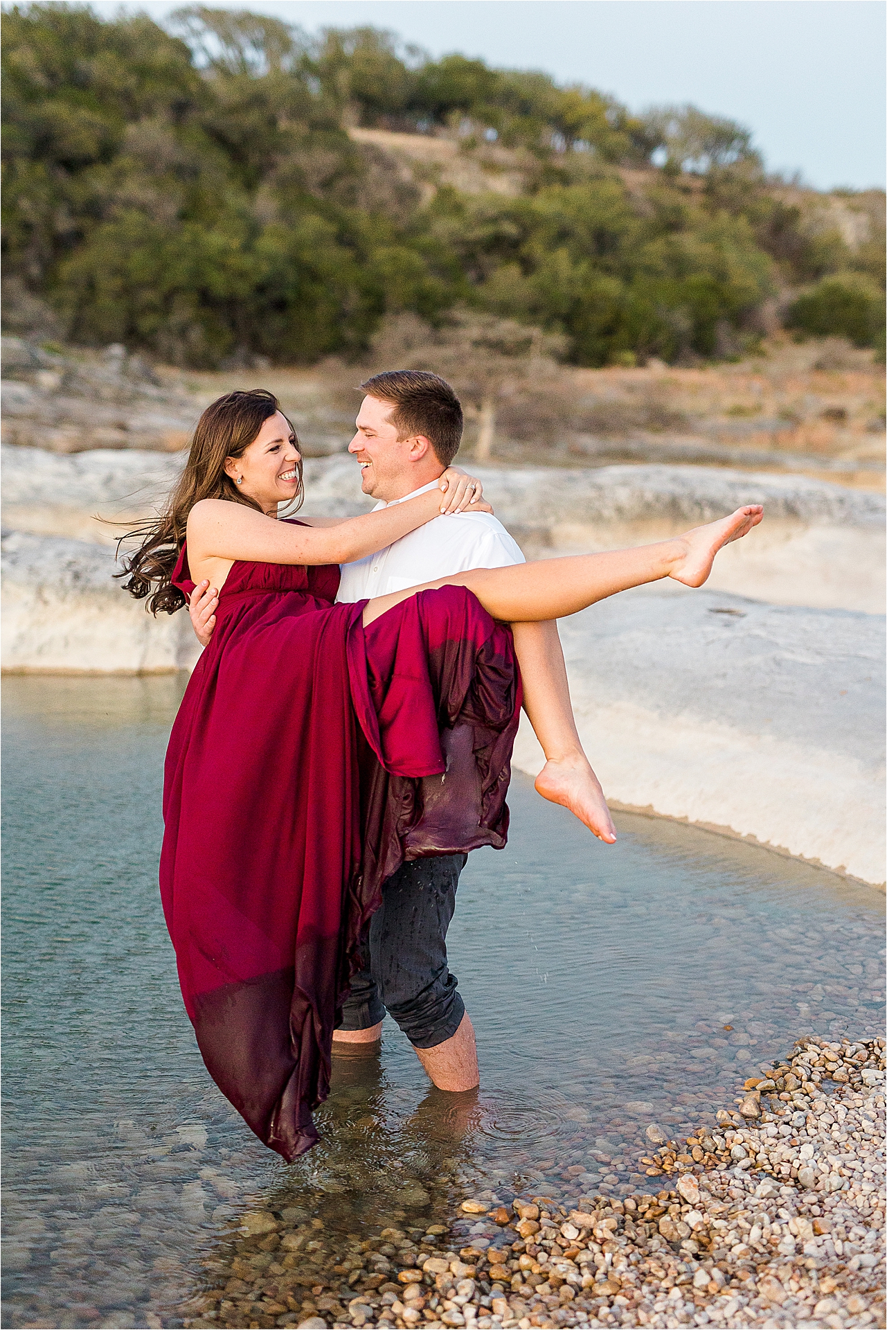 A groom lifts his bride to be in the water at Pedernales Falls State Park in the beautiful Texas Hill Country 