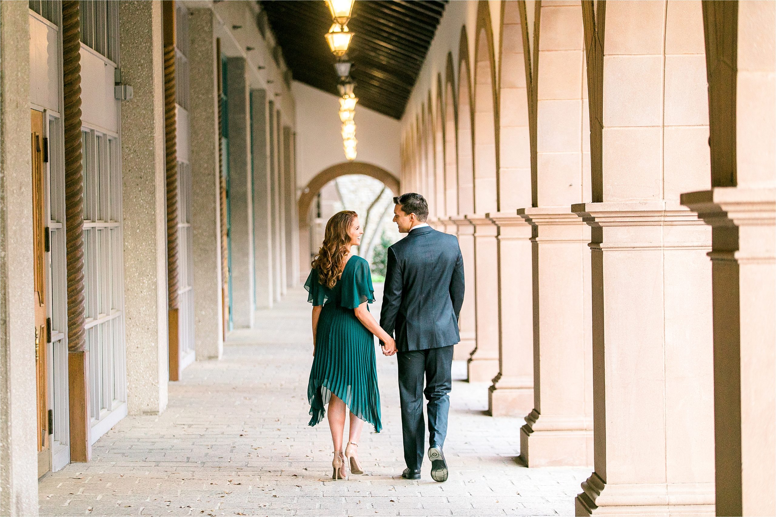  Miss Texas 2016 and her fiance hold hands as they walk away from the camera under a row of lanterns during their riverwalk inspired engagement session with San Antonio Wedding Photographer Jilian Hogan Photography 